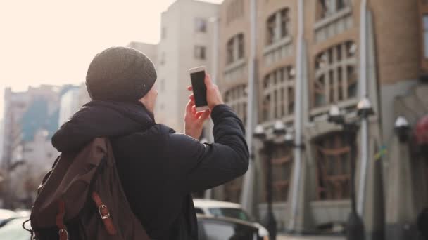 Man turist fotograferar byggnader i staden street — Stockvideo