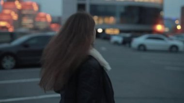Genç kadın akşam şehirde yürür