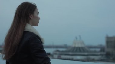 Genç kadın ileri city scape akşam için görünüyor