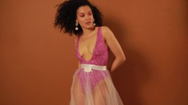 Turuncu arka planda stüdyoda poz güzel kadın