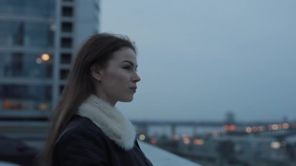 Jeune femme attend avec impatience paysage de la ville du soir — Video