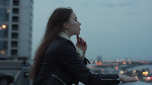 Jeune femme attend avec impatience paysage de la ville du soir — Video
