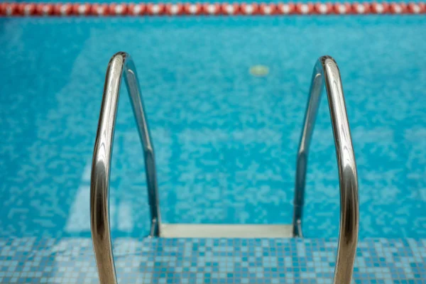 Piscina com escada e água azul — Fotografia de Stock