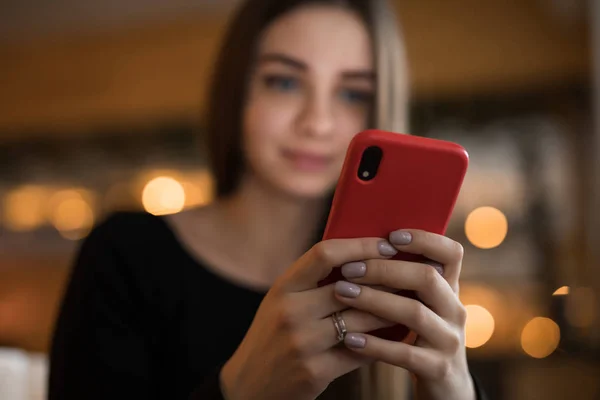 Nainen käyttää mobiili älypuhelin kahvilassa — kuvapankkivalokuva