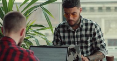 Genç erkek fotoğrafçılar Cafe dizüstü bilgisayarlar tarafından online çalışma bloglama