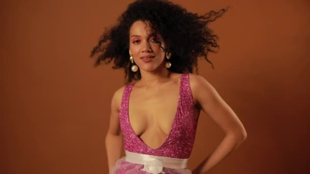 Schöne Frau posiert im Studio auf orangefarbenem Hintergrund — Stockvideo