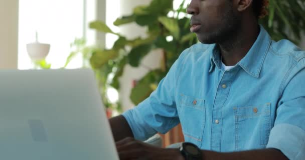 Homme afro-américain utilisant un ordinateur portable dans un café partageant des idées d'affaires — Video