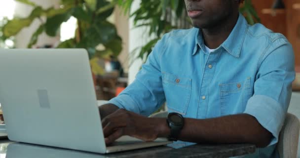 Αφρικανική αμερικανική άνθρωπος που χρησιμοποιούν φορητό υπολογιστή στο café κοινή χρήση επιχειρηματικών ιδεών — Αρχείο Βίντεο