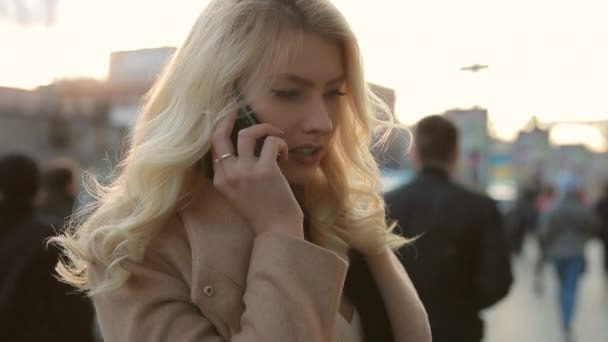 Женщина разговаривает по телефону в городе — стоковое видео