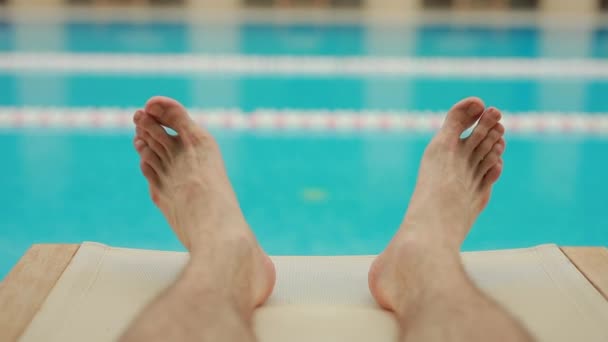 Мужские ноги расслабляются возле бассейна — стоковое видео