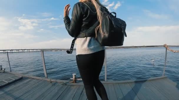 Žena, která si v pomalém pohybu užívá slunečného dne na molu řeky — Stock video