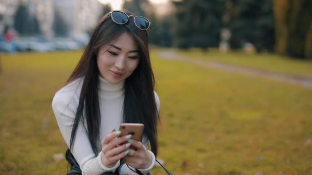 Asiatico donna utilizzando applicazione in smartphone all'aperto — Video Stock