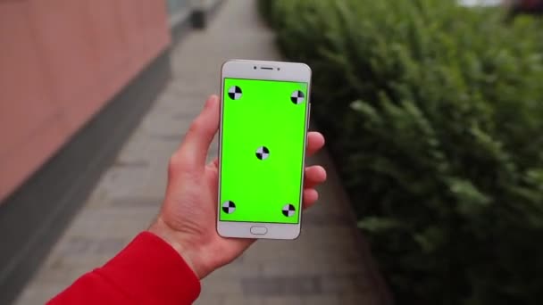 Point de vue, smartphone main tenant homme avec écran vierge marchant en ville 