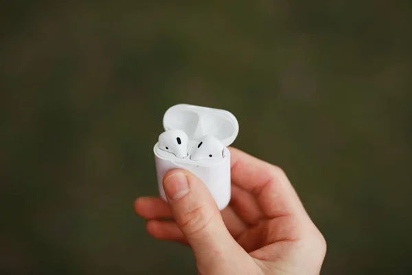 Ακουστικά ακουστικών Bluetooth σε αρσενικό χέρι — Φωτογραφία Αρχείου