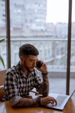 Cafe dizüstü bilgisayar tarafından çalışan şık yakışıklı işadamı Freelancer