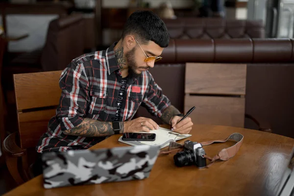 Чоловік планує свій робочий тиждень робити нотатки в блокноті — стокове фото