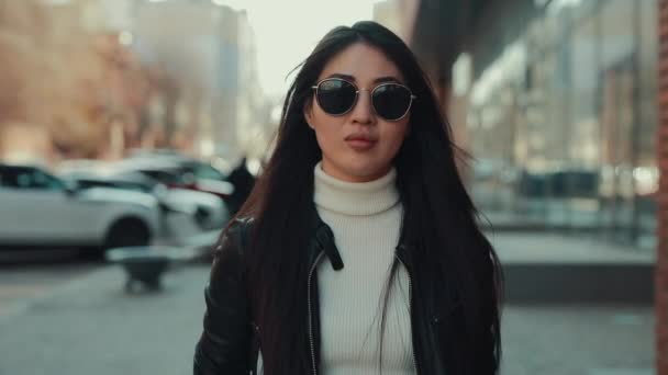 Mulher asiática caminha ao longo da cidade em óculos — Vídeo de Stock