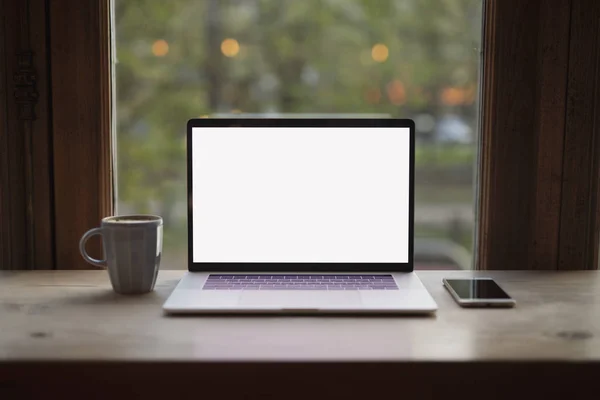 Penceredeki kafede dizüstü bilgisayarın boş boş ekranı