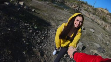 Pov, dağda yürüyüş yaptığı kadın için yardım eli veren adam