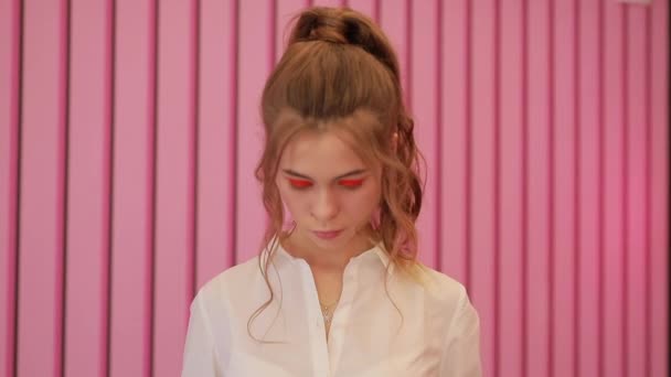 Κορίτσι που ποζάρει κοντά σε ροζ τοίχο — Αρχείο Βίντεο