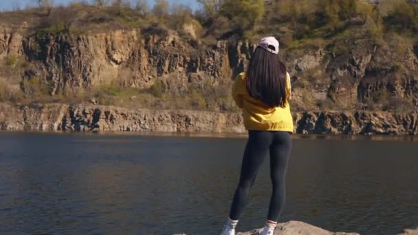 黄色のジャケットの女性観光客は自然の中で休息を楽しむ — ストック動画
