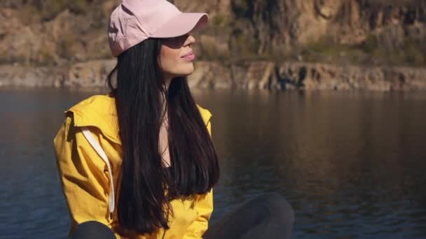 Kobieta turysta w żółtej kurtce cieszyć się odpoczynku na łonie natury — Wideo stockowe