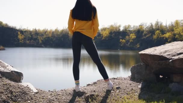 Женщина-туристка в желтой куртке отдыхает на природе — стоковое видео