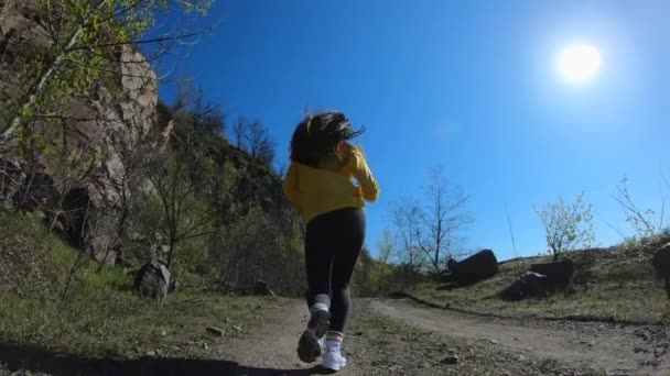 Женщина бегает на природе, горном ландшафте, в замедленном режиме — стоковое видео