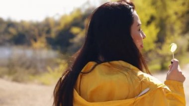 Arka planda manzara ile akrobatik takla atan genç bir kadın.