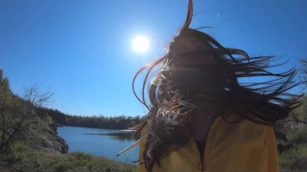 Mujer turista en chaqueta amarilla arroja pelo sobre la naturaleza — Vídeo de stock