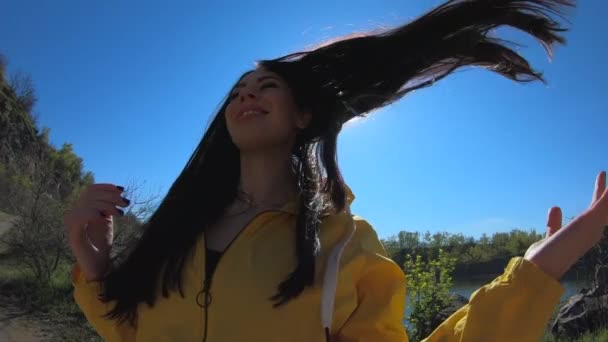 Donna turista in giacca gialla lanci di capelli sulla natura — Video Stock