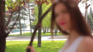 Şehir parkında Mutlu kadın bir yaz günü sahiptir, yüz ve göz kırpmak