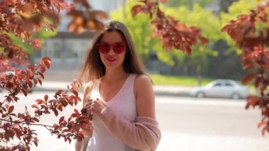 Parkta yürüyen pembe gözlüklü güzel kadın