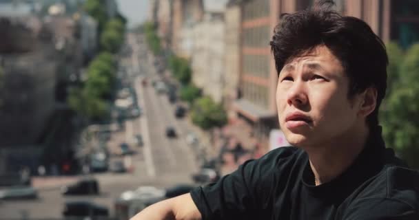 Asiático hombre sentado en la ciudad relajante al aire libre — Vídeo de stock