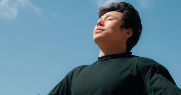 Man relaxing on a freedom with raised hands, blue sky background — Stock Video