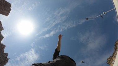 Adam mavi gökyüzü arka plan üzerinde akrobatik flip yapmak, süper yavaş hareket