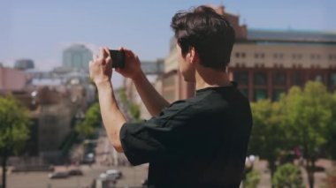 Akıllı telefon ile tanınmayan adam turist fotoğraf şehir arka görünümü