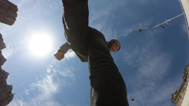 Hombre pasando sobre el fondo del cielo azul, super cámara lenta, vista inferior — Vídeos de Stock