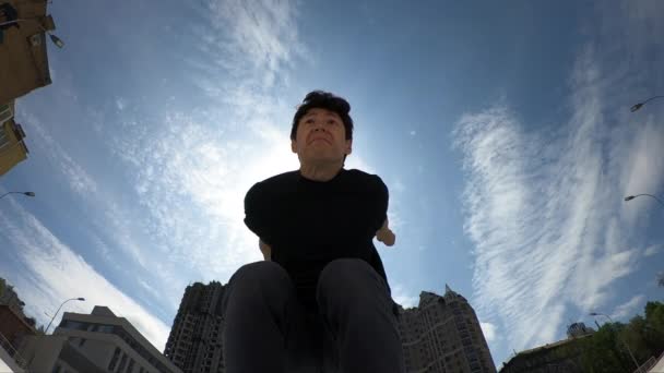 El hombre hace acrobática espalda voltear sobre fondo azul cielo, super cámara lenta — Vídeo de stock