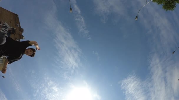 Человек делает акробатический переворот над голубым небом фон, супер медленное движение — стоковое видео