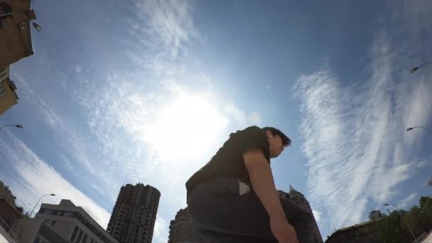 El hombre hace la vuelta sobre el fondo azul del cielo, super cámara lenta — Vídeo de stock