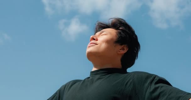 Hombre relajándose sobre un fondo de cielo azul y libertad — Vídeo de stock