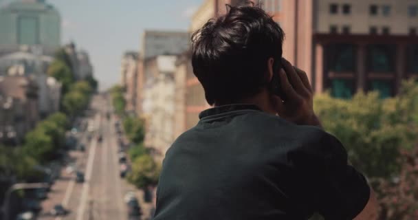 Back View man pratar med smartphone i City — Stockvideo