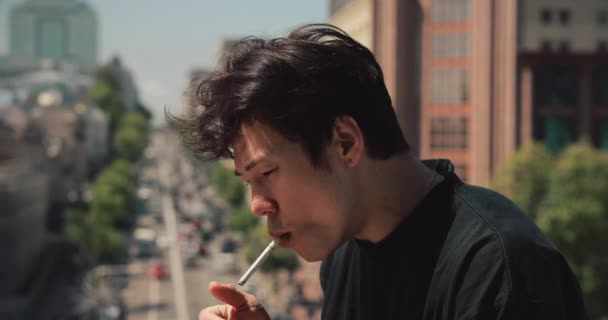 Asiatisk man röker cigarett i staden — Stockvideo