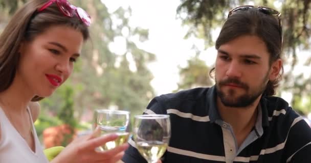 Couple date, man and woman clink glasses and drinks wine — Stock Video