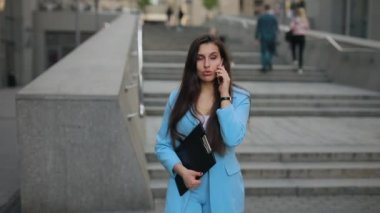 İş kadını işten sonra telefonla konuşarak eve gidiyor