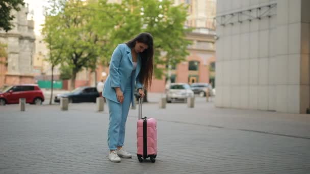 A nőnek van egy tipikus problémája a bőröndjével a városban, a fogantyú nem csúszik ki. — Stock videók