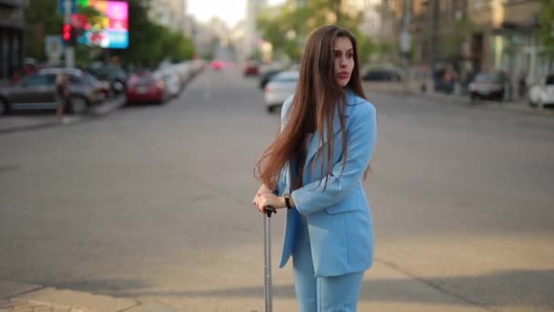 Nő bőrönddel vár taxi egy városban — Stock videók
