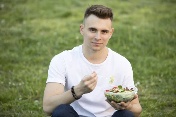 Портрет людини, що їсть свіжий салат влітку — стокове фото