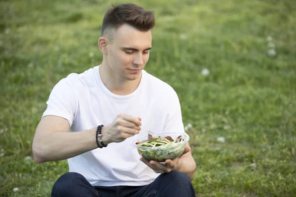 Man eating fresh salad at summer